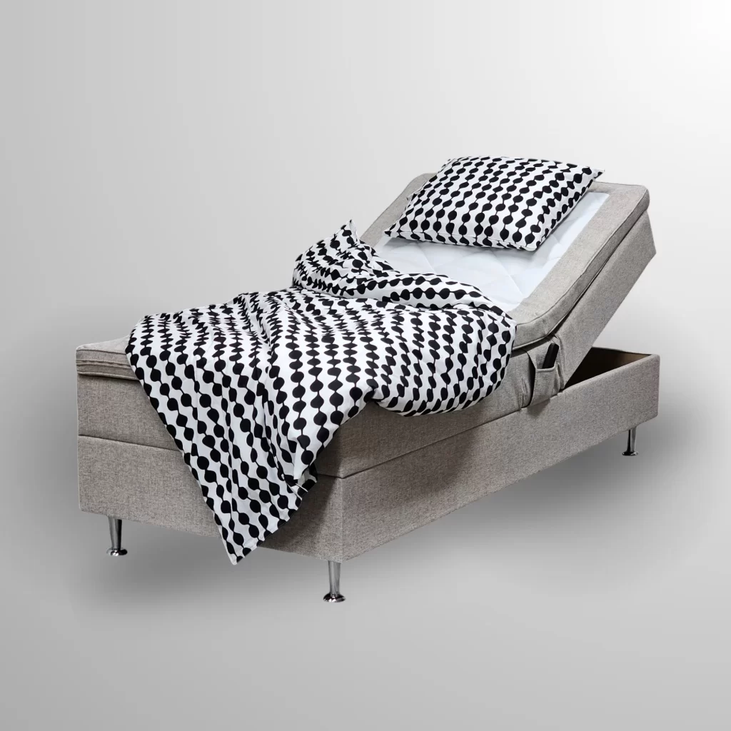 Honey Hotelbeds moottorisänky taustattomassa kuvassa, jossa säädettävä selkänoja, harmaa verhoilu ja mustavalkoiset kuviolliset vuodevaatteet.